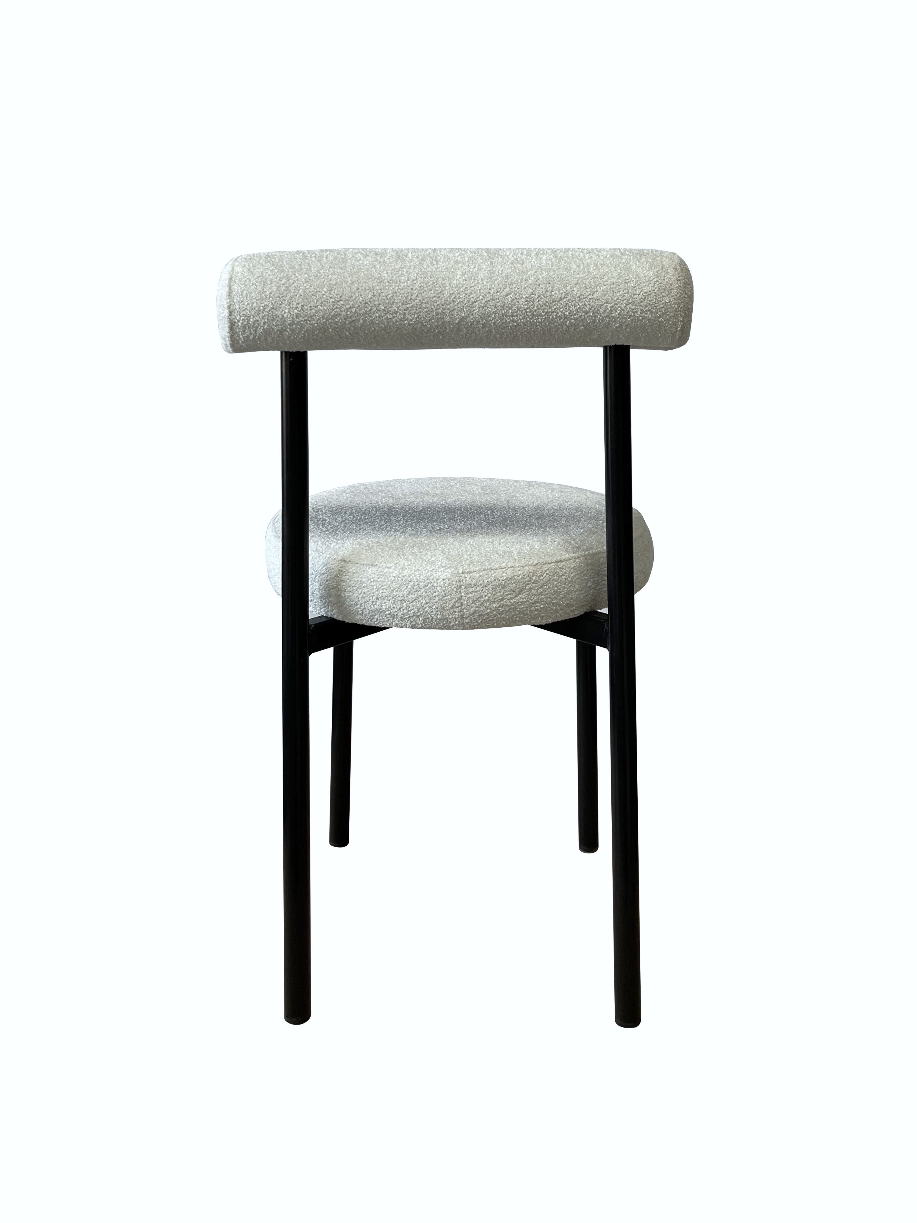 Witte bouclé stoel met stevig metalen frame en modern design, geschikt voor woonkamer of kantoor