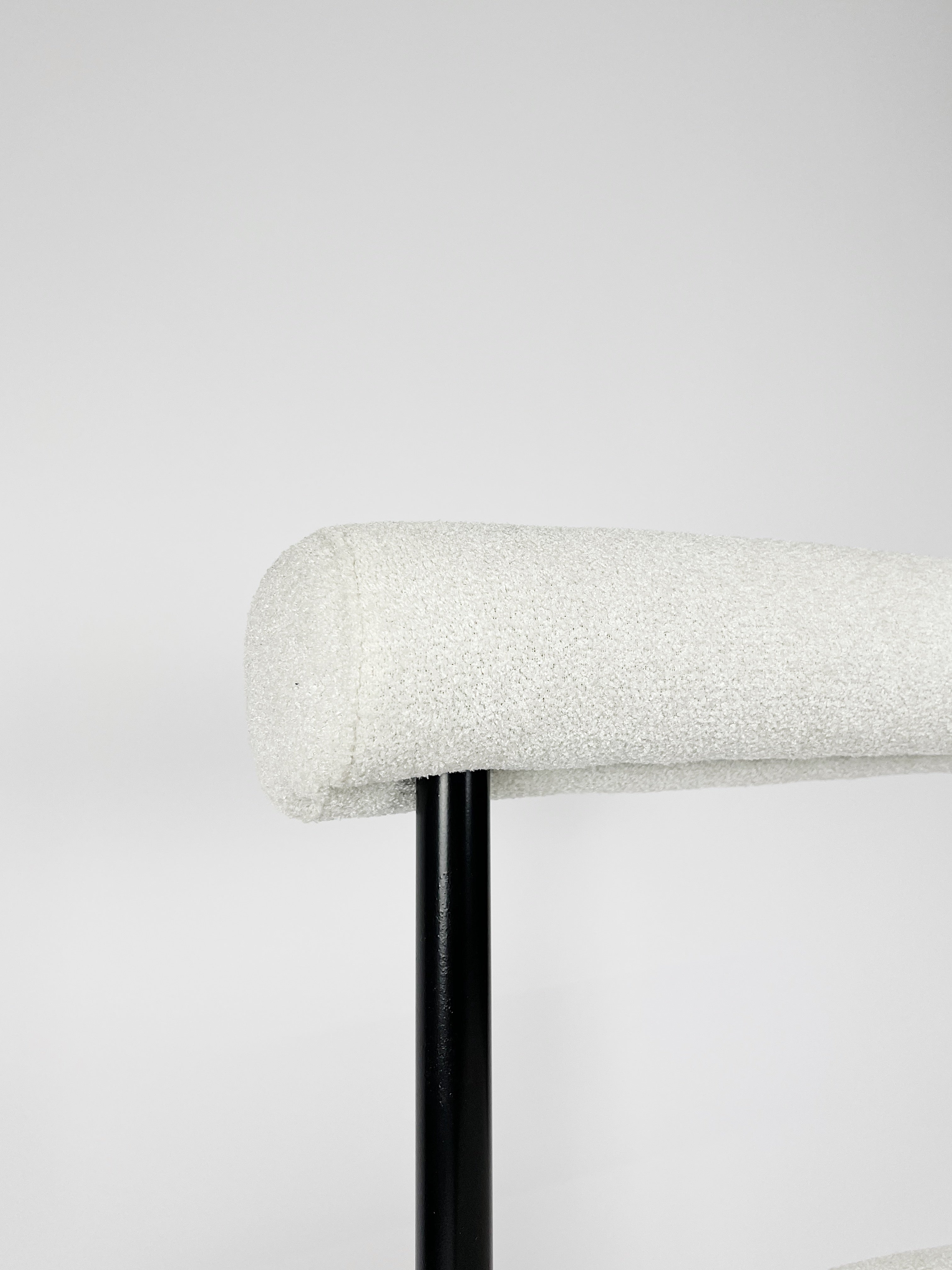 Witte bouclé stoel met stevig metalen frame en modern design, geschikt voor woonkamer of kantoor